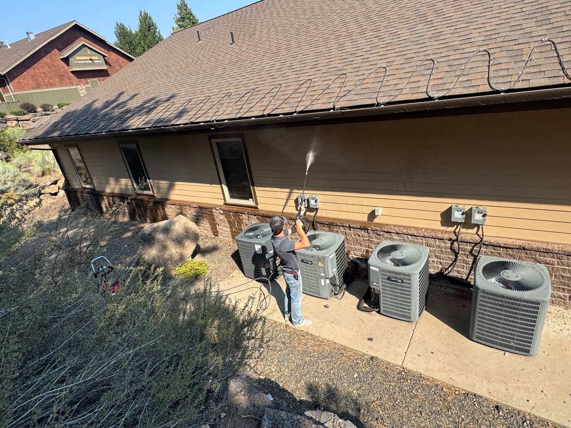 A Clips Lawn Care crew member pressure washing a commercial property